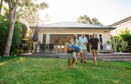 Get a home/renters quote - family playing in the yard, front of house in the summer